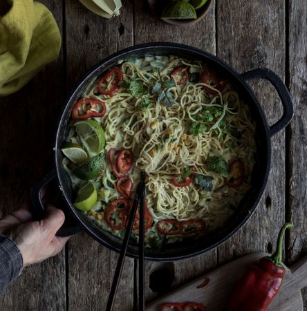 Green curry noodles in pot on table