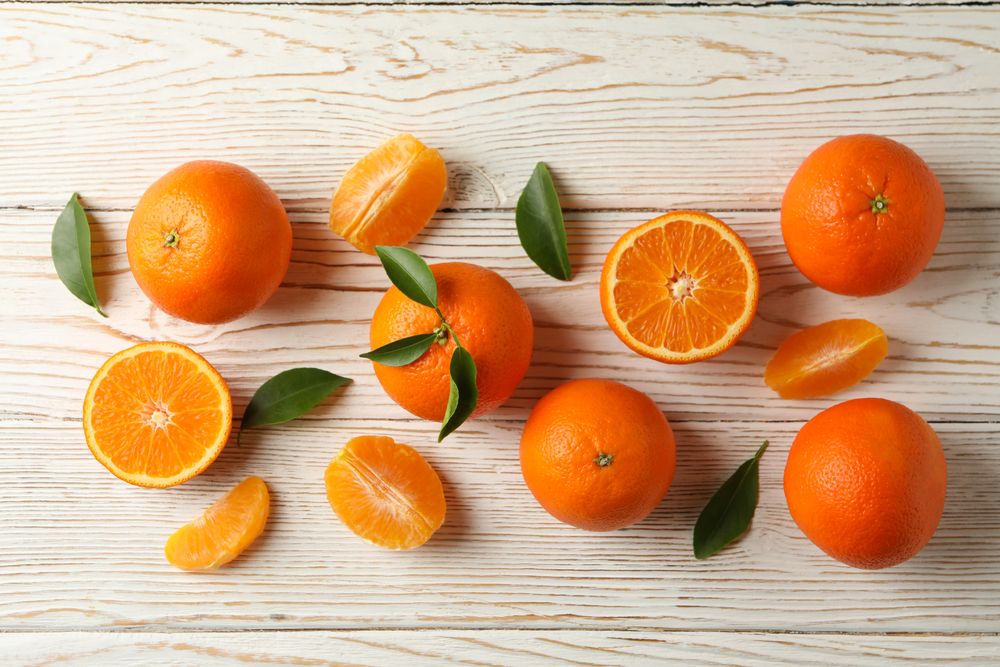Ripe sweet mandarins on wooden background, top view