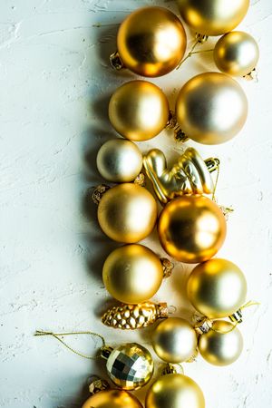 Top view of line of golden Christmas baubles on table