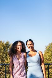 Back view of two girlfriends on a bridge