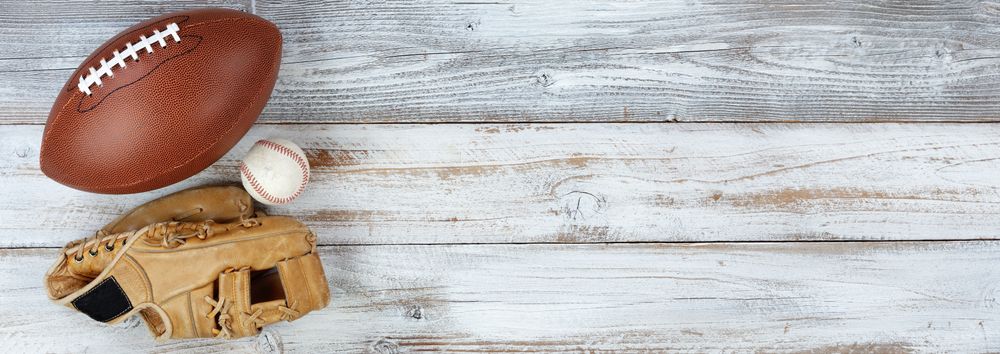 Various sports equipment on rustic wood with plenty of copy space