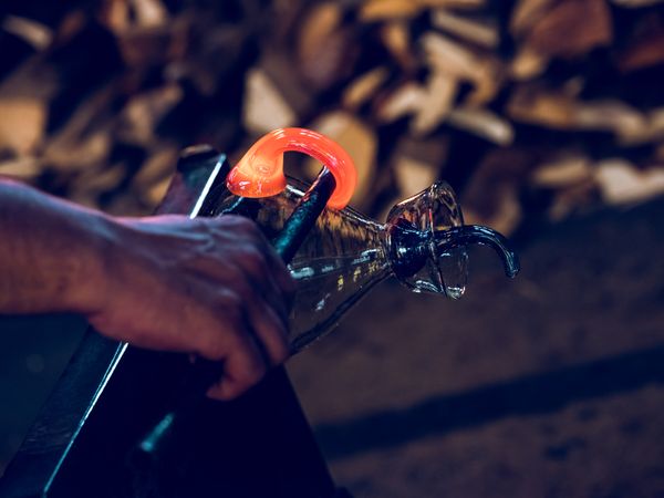 Crop craftsman shaping glass handle in factory