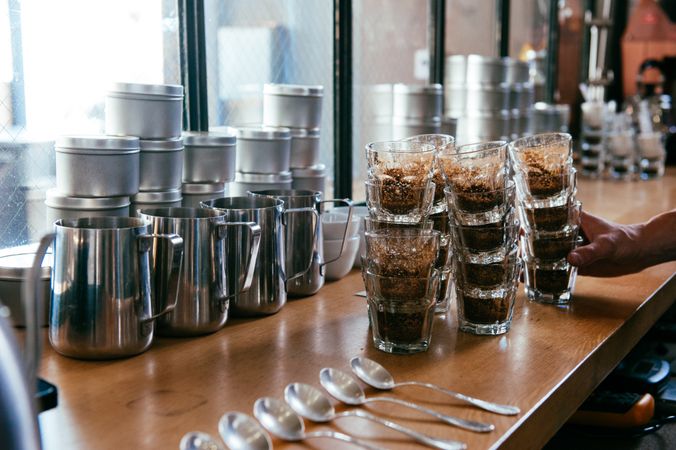 Milk frothers, cups and spoons on coffee counter