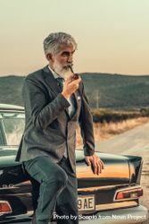 Man in gray smoking pipe beside car outdoor 4Nx7A0