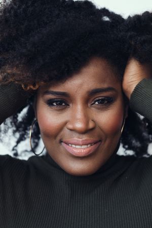 Closeup of thoughtful Black woman with her hand in her curly hair