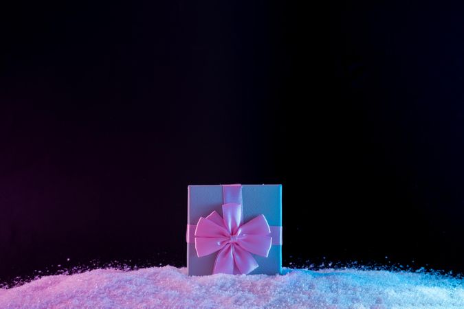 Wrapped present on vibrant bold gradient holographic colors on snow