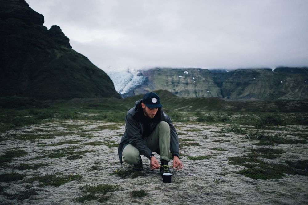 Man tying shoe on overcast day while out hiking