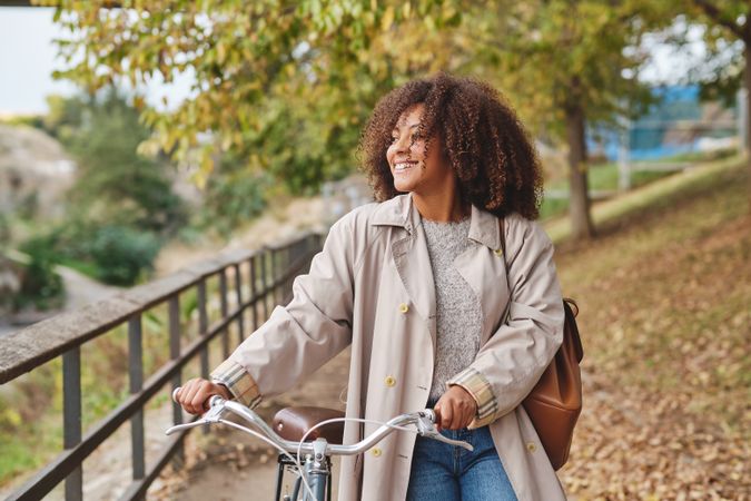 Positive Black Latina woman with bicycle in park