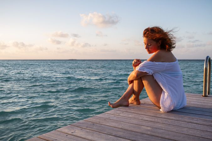 Young woman on pier near sea