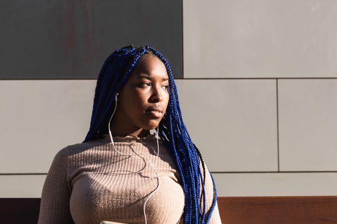 Serene Black woman in earphones on street