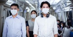 Asian people in facemask standing in metro car