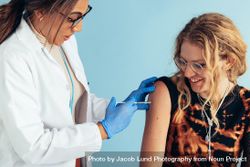 Woman receiving vaccine by a doctor 5XnwVb