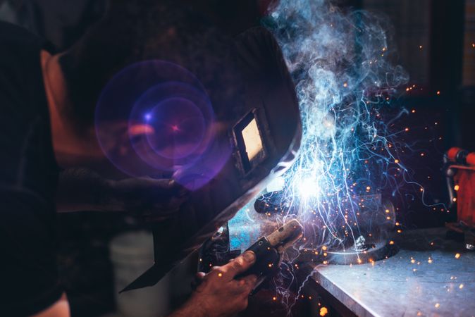 Professional welder in mask welding metal