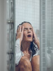 Sad woman crying in shower