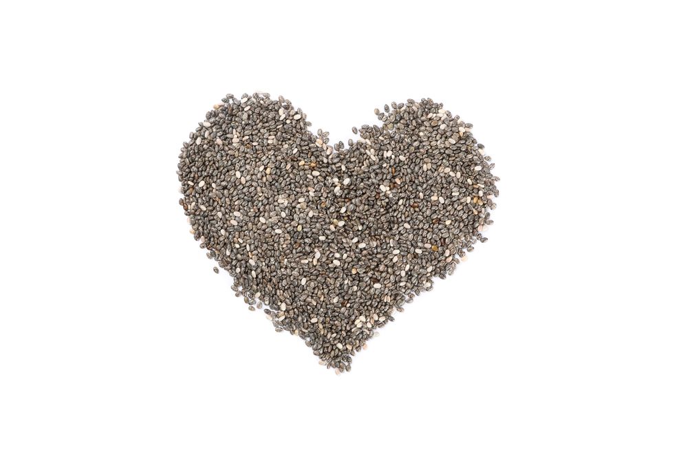 Heart laid out of chia seeds isolated on plain background