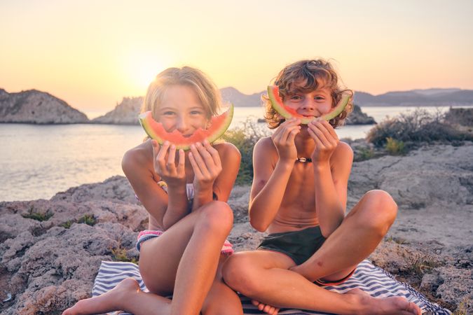 Happy brother and sister during picnic at seaside