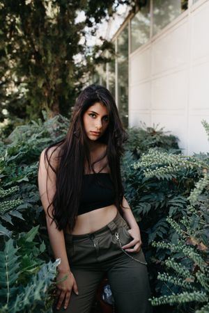 female standing near bushes