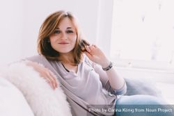 Portrait of a happy young woman sitting on a couch 20Ky74