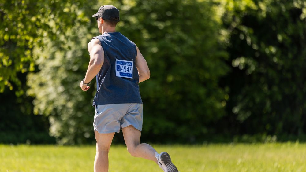 Portrait of a Young Athletic Male Jogger Running in a Park on a Health Trail.