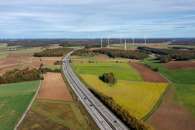 Aerial shot with german highway and wind turbines in autumn scenery.