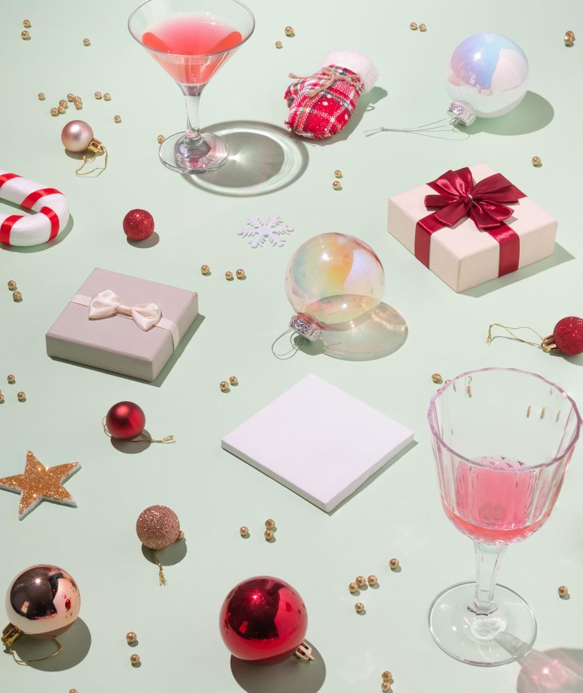 Scene of holiday items with wine glasses, presents, baubles and decorations