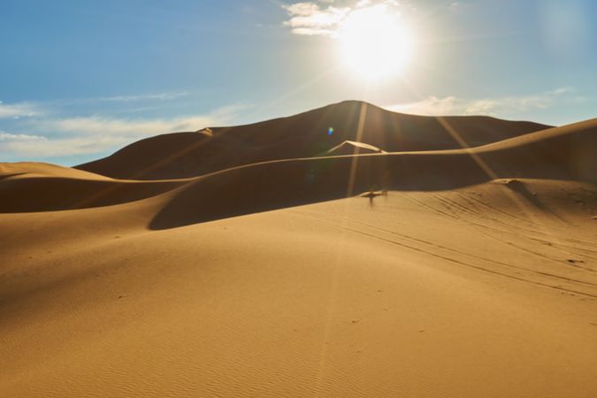 Sand dunes and blue sky with sun
