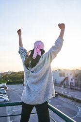 Woman raising arms and celebrating recovery from breast cancer