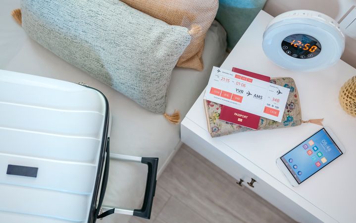 Suitcase on the bed and air ticket on the bedside table