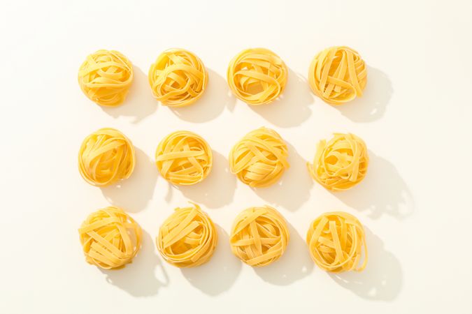 Flat lay composition with different pasta on light background, space for text