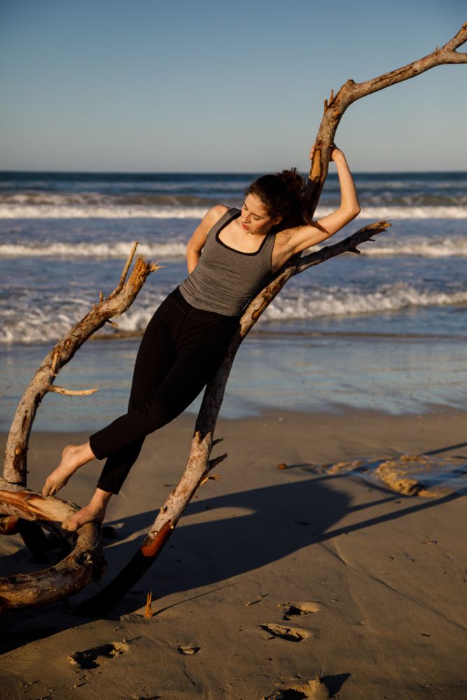 Young woman near twig and water on shore