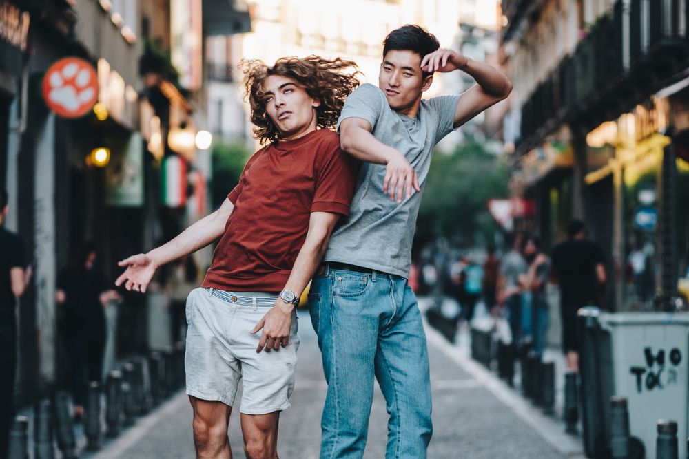 Courageous multiethnic male friends jumping and having fun on street