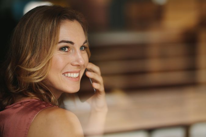 Closeup of a woman talking over mobile phone looking away