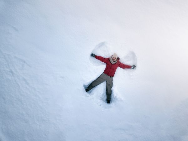 Smiling man lying on fresh clean snow