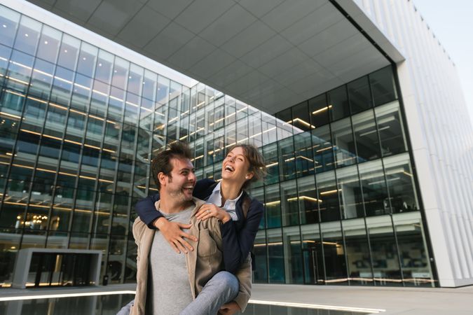 Cheerful couple having fun and hugging on street in downtown