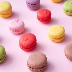 Pastel pink table top with colorful macarons pattern