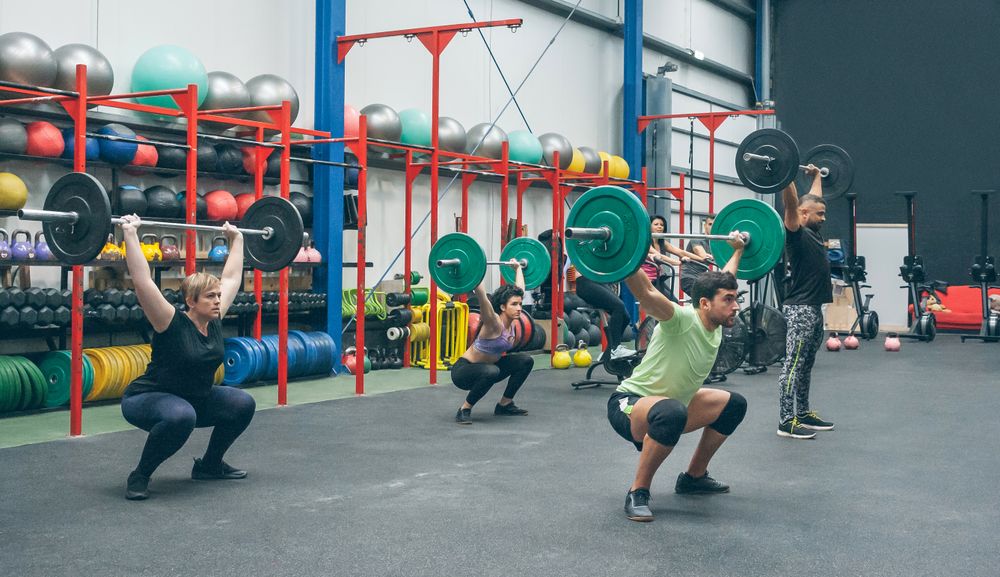 People practicing weightlifting lifting weights in the gym