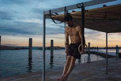 Athletic man balancing on gymnastic rings