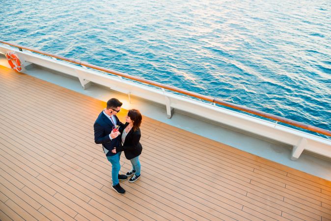 Couple hugging on deck of ship in blue sea