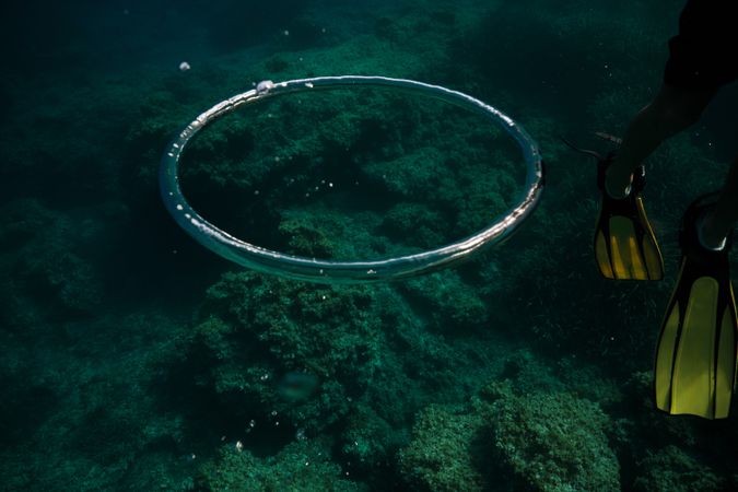 Air rings near diver in deep ocean