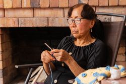 Serenity in stitches. Latina woman knits at home.