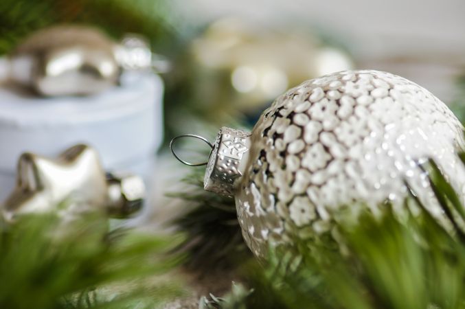 Close up of textured Christmas bauble nestled in pine branch