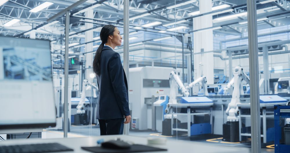 Electronics Manufacturing Technician Working on a Tablet Computer at a Factory Space. Asian Female Specialist Developing, Maintaining, and Fine-Tuning Programs for Machine Production and Assembly