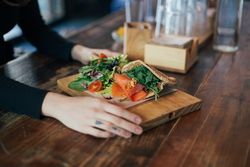 Hands with delicious pita sandwich in cafe