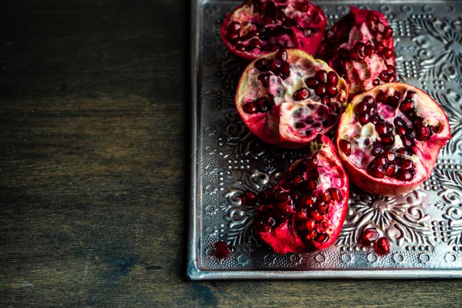 Open pomegranates on ornate silver trey
