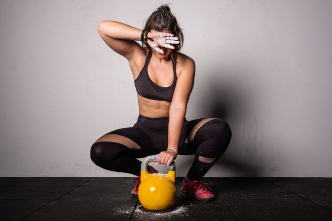 woman lifting kettlebell in gym