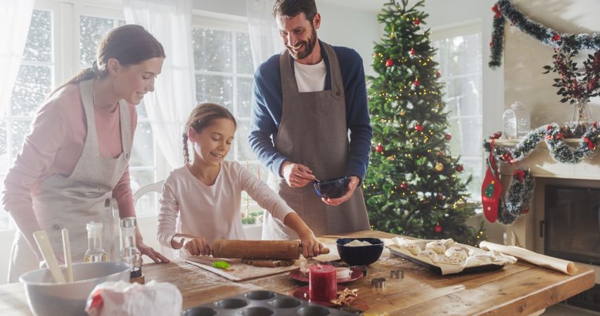 Portrait of Little Cute Girl Learning How to Make Cookies and Celebrating her Achievement with her Parents.