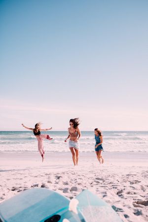 Group of women standing in motion in the sand at the beach
