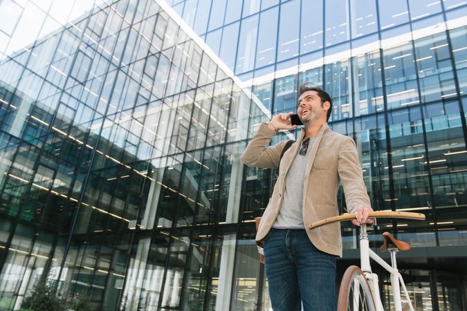 Man phoning while standing against modern building in downtown