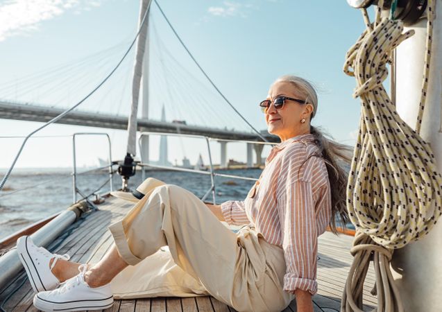 Stylish mature woman lounging on a yacht bow