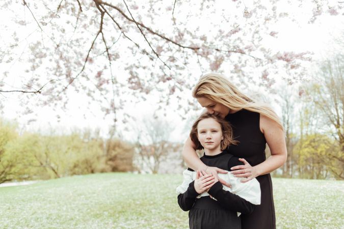 Mother and daughter embracing in park